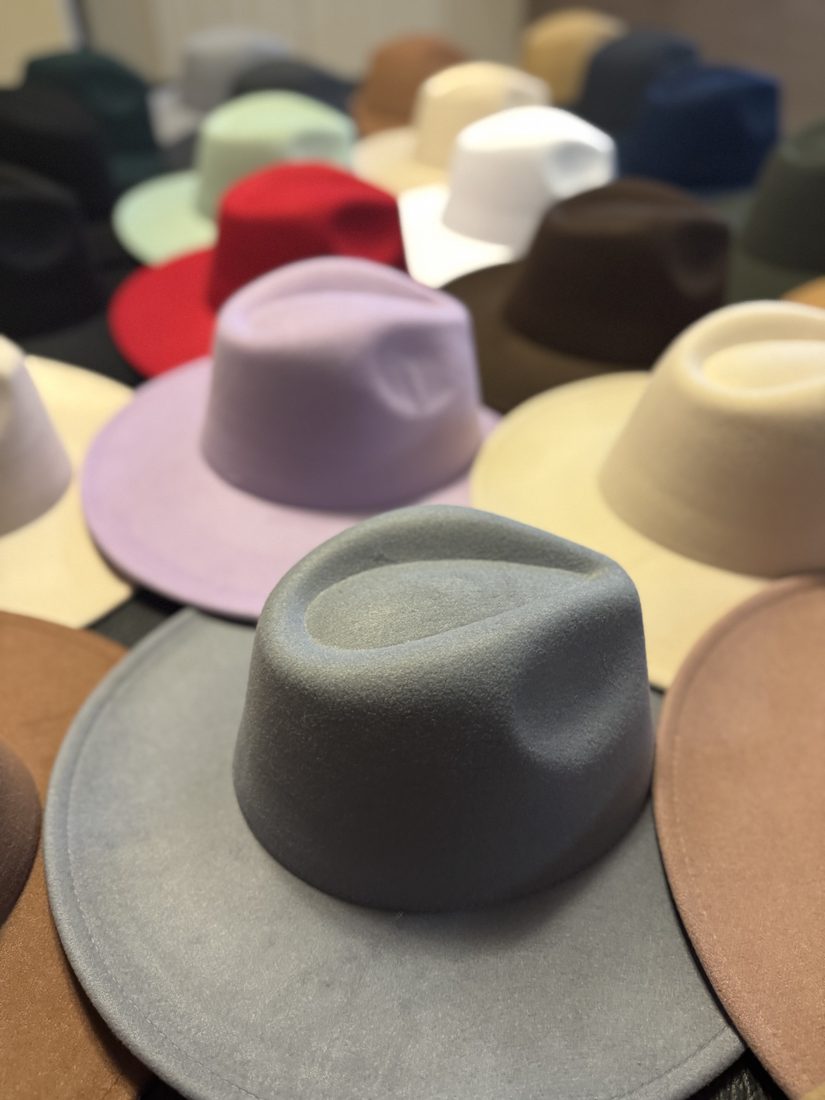 Rows of blank felt fedoras in different colours