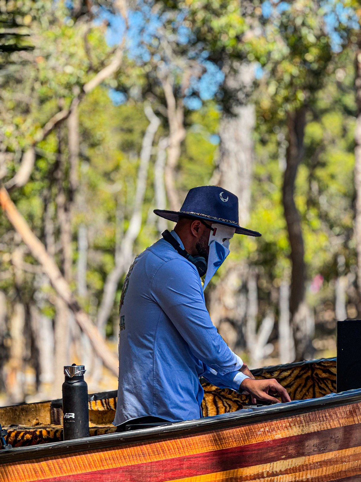 Man wearing navy fedora outdoors among trees