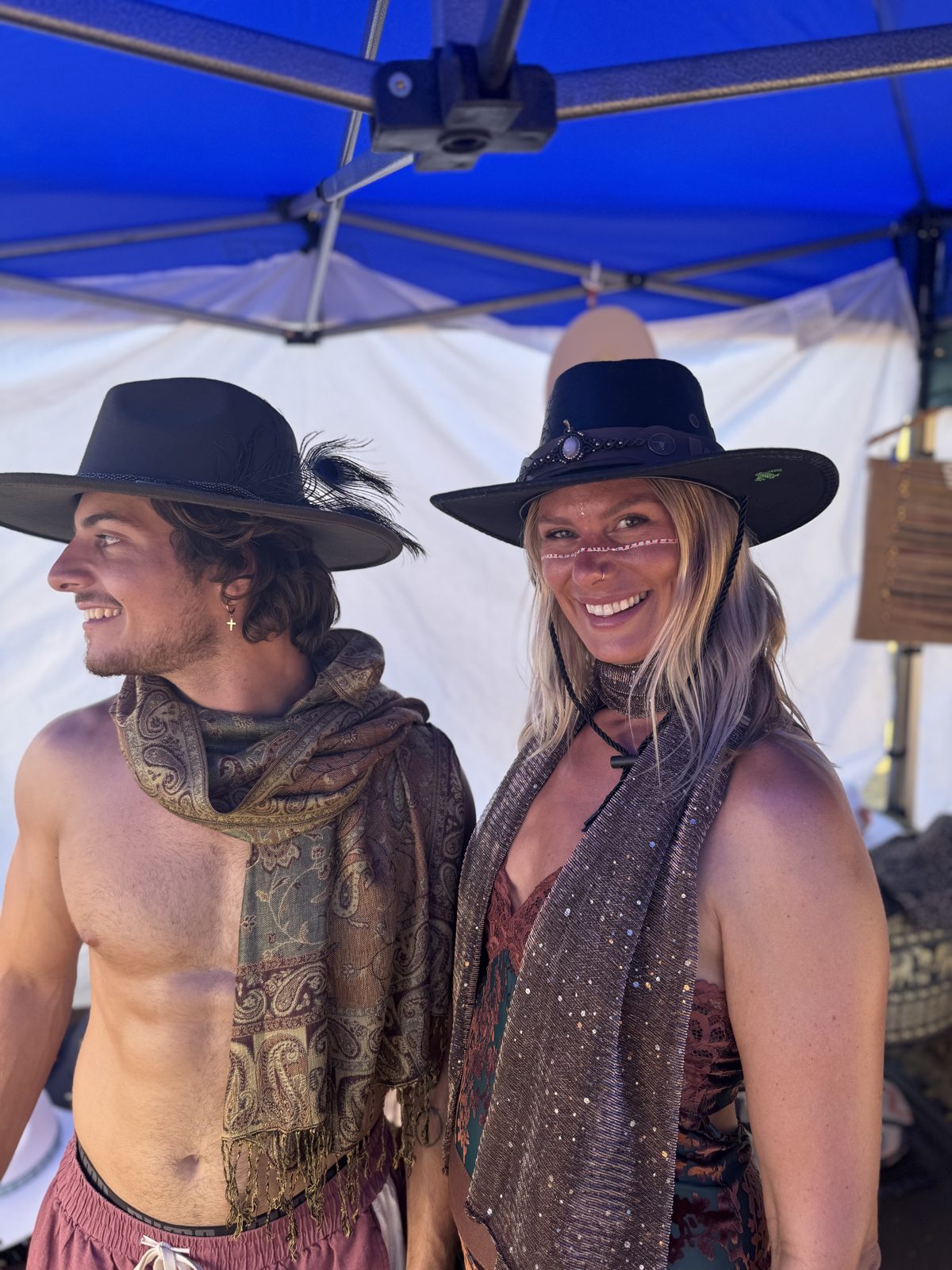 Two people wearing JHATS_CO hats outdoors